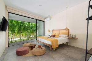 a bedroom with a bed and a large window at XP Tulum in Tulum