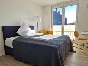 a bedroom with a bed with a large window at Stadt-Appartement CityLife in Bielefeld