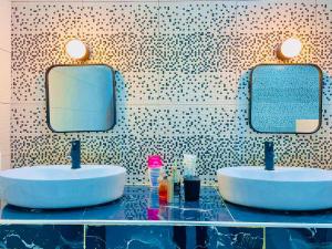 een badkamer met 2 wastafels en spiegels op een aanrecht bij Villa avec piscine in Somone