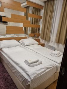a bedroom with two beds with towels on them at Apartman KUTIJA Kopaonik in Kopaonik +47 photos