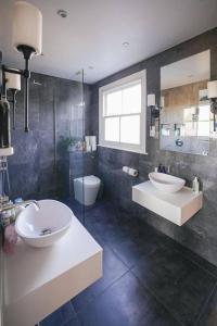 a large bathroom with two sinks and a toilet at Stunning Modern 5-Bed House in Central London in London