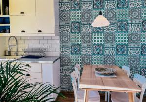 a kitchen with a wooden table and chairs and a wall with tiles at Orient pri hokejovom štadióne in Nivy
