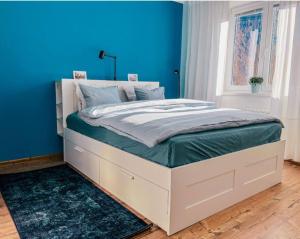 - une chambre bleue avec un lit blanc et un mur bleu dans l'établissement Orient pri hokejovom štadióne, à Nivy