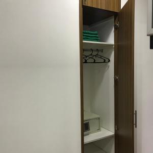 a closet with a door open with a microwave at Depto Cívico in San Juan