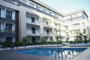 een appartementencomplex met een zwembad ervoor bij Luxury Suite 42m2 @ Embassy Gardens Cantonments in Cantonments