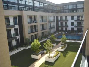 een appartementencomplex met een binnenplaats met bomen en planten bij Luxury Suite 42m2 @ Embassy Gardens Cantonments in Cantonments