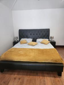 Un dormitorio con una cama con almohadas amarillas. en Cosy Studio Flat en Bexleyheath