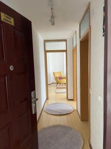 un couloir avec une porte et une chambre avec une chaise dans l'établissement FG 2 apartment, à Gnjilane