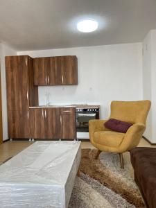 een woonkamer met een bed en een stoel bij FG 2 apartment in Gnjilane