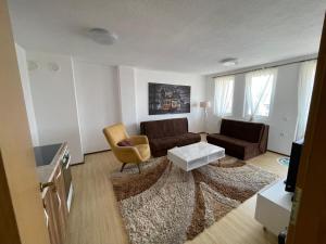 uma sala de estar com um sofá e uma mesa em FG 2 apartment em Gnjilane