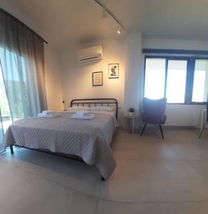 伊古邁尼察的住宿－Μοντέρνο Στούντιο, με Θέα，一间卧室配有一张床、一把椅子和窗户。