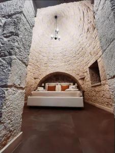2 Betten in einem Zimmer mit einer Steinmauer in der Unterkunft Scardino Trulli in Locorotondo