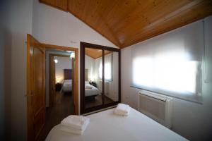 a bedroom with a white bed with a mirror and a bed sidx sidx sidx sidx at Apartamento Santa Bárbara in Castilleja de la Cuesta