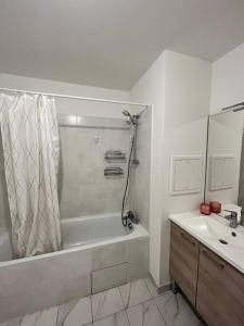 uma casa de banho branca com uma banheira e um lavatório em Le cocon marnais - appart 2P em Villiers-sur-Marne