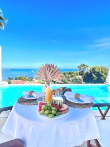 a plate of food on a table by a pool at Atalaya Boutique in Denia