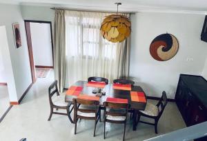Kololo 3BR with Garden, 500m to Acacia Mall في كامبالا: طاولة طعام وكراسي في الغرفة