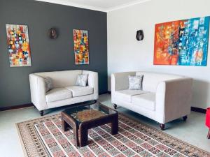 a living room with two couches and a coffee table at Spacious Residence with Garden Close to Acacia Mall Kololo in Kampala