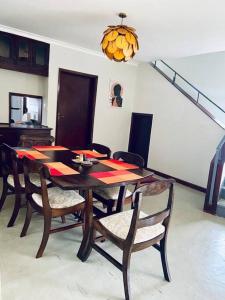 a dining room with a wooden table and chairs at Spacious Residence with Garden Close to Acacia Mall Kololo in Kampala