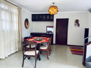 a dining room with a wooden table and chairs at Spacious Residence with Garden Close to Acacia Mall Kololo in Kampala