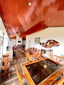 un soggiorno con soffitto in legno, tavolo e sedie. di Monteverde Ecolove a Monteverde Costa Rica