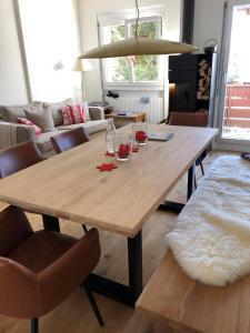 a wooden table in a living room with wine glasses on it at Sonnendurchflutete Familienwohnung in Platta