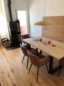 a dining room with a wooden table and chairs at Sonnendurchflutete Familienwohnung in Platta