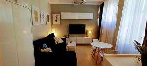 a living room with a black couch and a table at Drzewna Apartamenty - Niepodległości in Zielona Góra