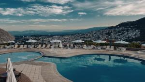 a swimming pool with tables and chairs and a city at Hotel Montetaxco in Taxco de Alarcón