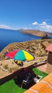 a person sitting under a colorful umbrella on the grass at Ecolodge El descanso in Comunidad Yumani