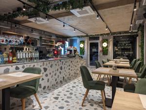 ein Restaurant mit Holztischen und grünen Stühlen in der Unterkunft Lignum Hotel in Miskolctapolca