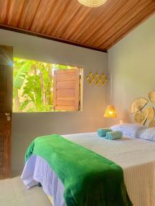 um quarto com uma cama grande e uma janela em Casa Hibiscus Beach Club Ipioca Maceió em Maceió