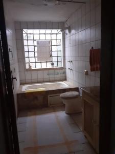 łazienka z wanną, toaletą i oknem w obiekcie Chalé ensolarado, bairro Frei Rogerio w mieście Lages