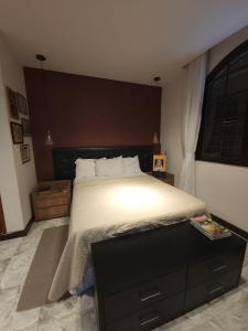 a bedroom with a large bed with a black headboard at Casa em mangaratiba in Mangaratiba