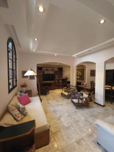 a large living room with a couch and chairs at Casa em mangaratiba in Mangaratiba