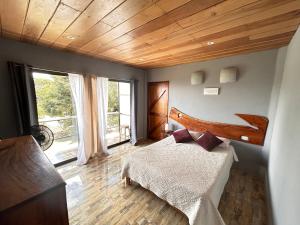 a bedroom with a bed and a wooden ceiling at Monteverde Ecolove in Monteverde Costa Rica