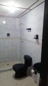 a bathroom with a black toilet and a shower at Villa Myrian in Villanueva