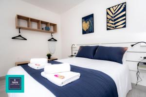a bedroom with a bed with towels on it at Mara 1 Playa del Burrero junto al mar wifi gratis in Ingenio