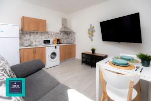 a small kitchen and living room with a tv on the wall at Mara 1 Playa del Burrero junto al mar wifi gratis in Ingenio