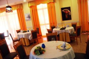 a dining room with two tables with white table cloths at Hotel San Giacomo in Monteprandone