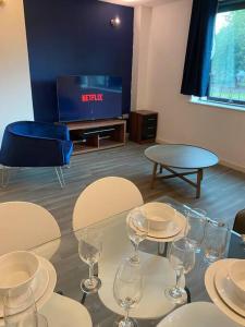 een tafel met wijnglazen en een tv in een kamer bij Spacious 2 Bedroom City Centre Apartment by Cloud Suites in Manchester