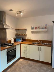 een keuken met witte kasten en een fornuis met oven bij Spacious 2 Bedroom City Centre Apartment by Cloud Suites in Manchester