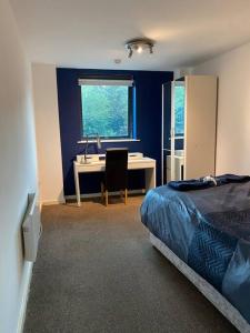 een slaapkamer met een bed, een bureau en een wastafel bij Spacious 2 Bedroom City Centre Apartment by Cloud Suites in Manchester