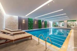 a large swimming pool in a building with a pool at Three Bedroom furnished apartment in north Riyadh - شقه 3 غرف مميزه ومتكامله في شمال الرياض مع مرافق فريده in Riyadh
