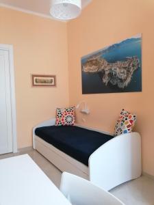 1 dormitorio con 1 cama y una pintura en la pared en Raggio di Sole, en Gaeta