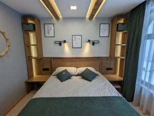 Un dormitorio con una cama grande con dos almohadas. en Pine & Wine Sauna Apartment, en Pamporovo