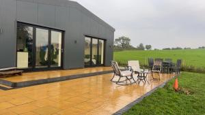 eine Terrasse mit Stühlen und einem Tisch vor einem Haus in der Unterkunft Immaculate 3-Bed Barn in Uttoxeter in Uttoxeter