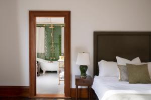 a bedroom with a bed and a bathroom with a tub at Mt Vernon Villa by MajorDomo in  Waipukurau