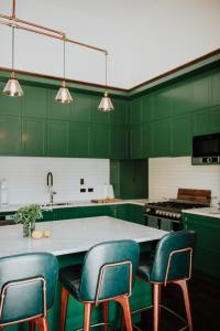 eine grüne Küche mit grünen Stühlen und einer Theke in der Unterkunft Mt Vernon Villa in  Waipukurau