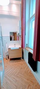 a bathroom with a sink and a wooden floor at Drzewna Apartamenty - Wrocławska in Zielona Góra