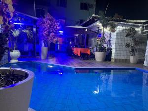 a swimming pool at night with purple lights at Hotel Pousada Irmaos Freyhardt in Rio de Janeiro